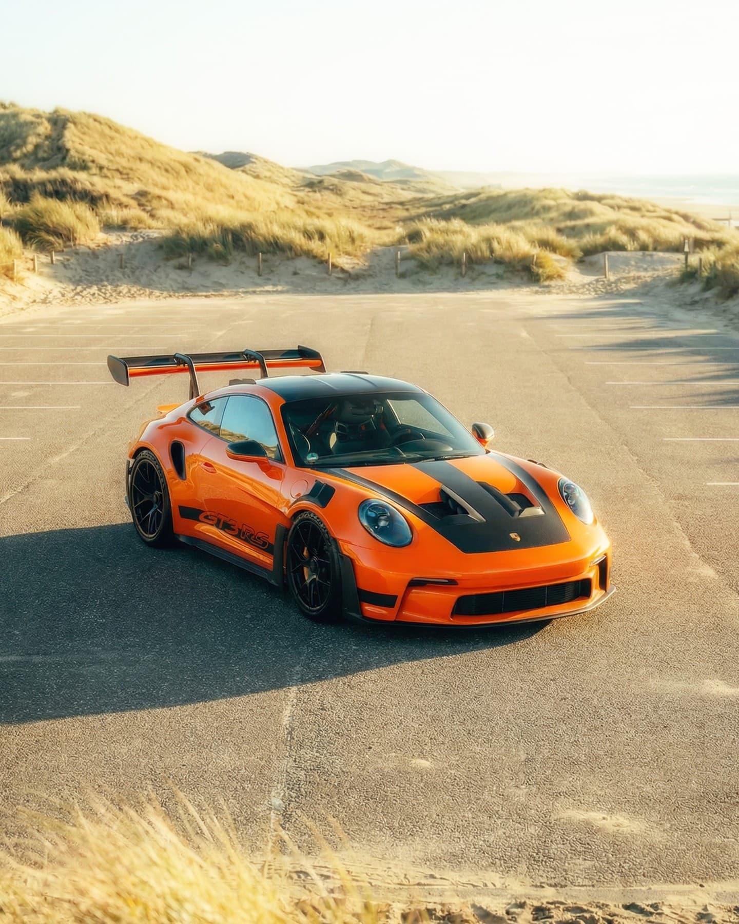 Orange Porsche GT3 RS on coastal road